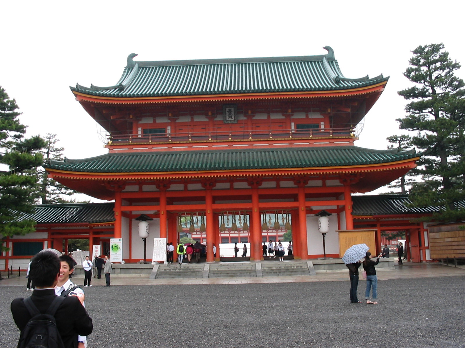 orange building with green roof and tourists walking around