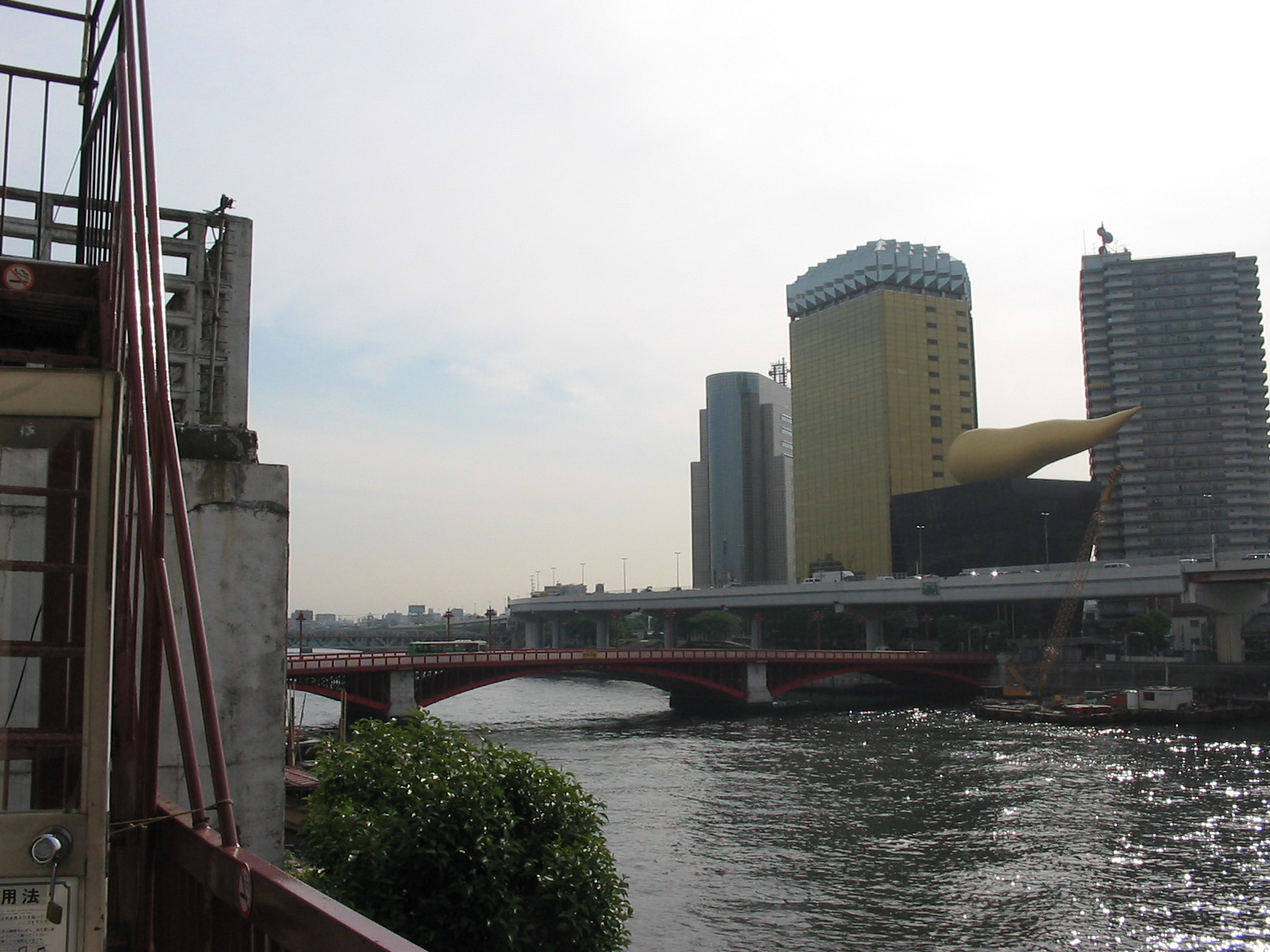 view of bridge with black building with golden flame on top